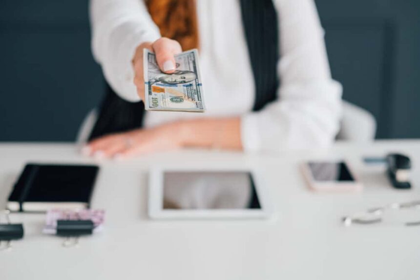 under the table jobs Do business online, get cash salary. Female extending dollar bills. Making money on internet. Income, payment, funds.