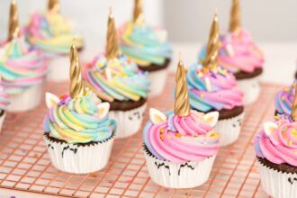 A tray of homemade unicorn-themed decorated cupcakes.